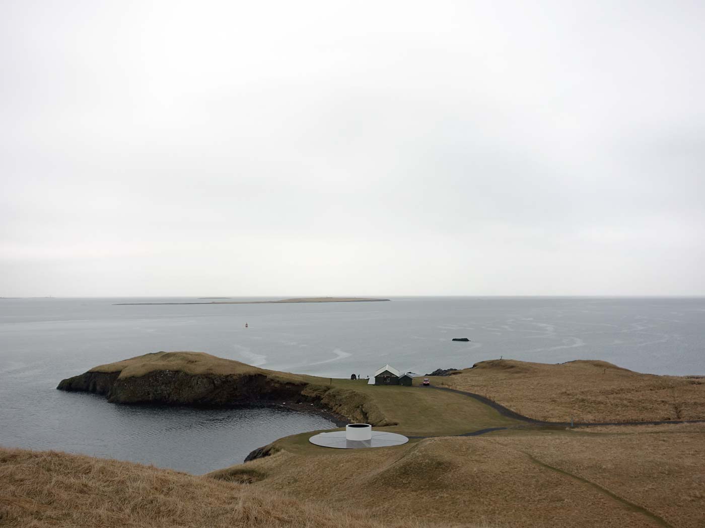 Viðey. Frühjahrsfahrt (mit Regen) nach Viðey. - Auf Viðey. VI. Vorne, der weisse Zylinder, ein Kunstwerk von Yoko Ono - <a href='http://imaginepeacetower.com' target='_blank' class='linksnormal'>Imagine Peace Tower</a> und <a href='http://imaginepeace.com' target='_blank' class='linksnormal'>hier</a>. (10.05.2013)